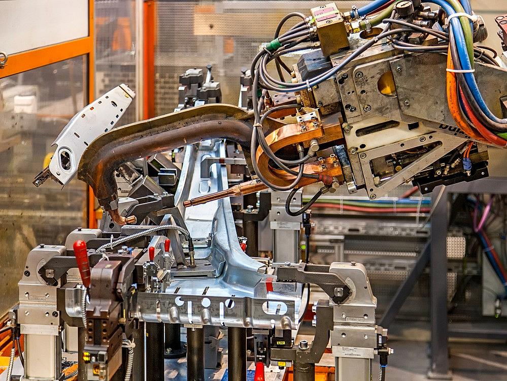 Schwei&szlig;roboter bearbeitet metallische Bauteile in der automatisierten Baugruppenfertigung