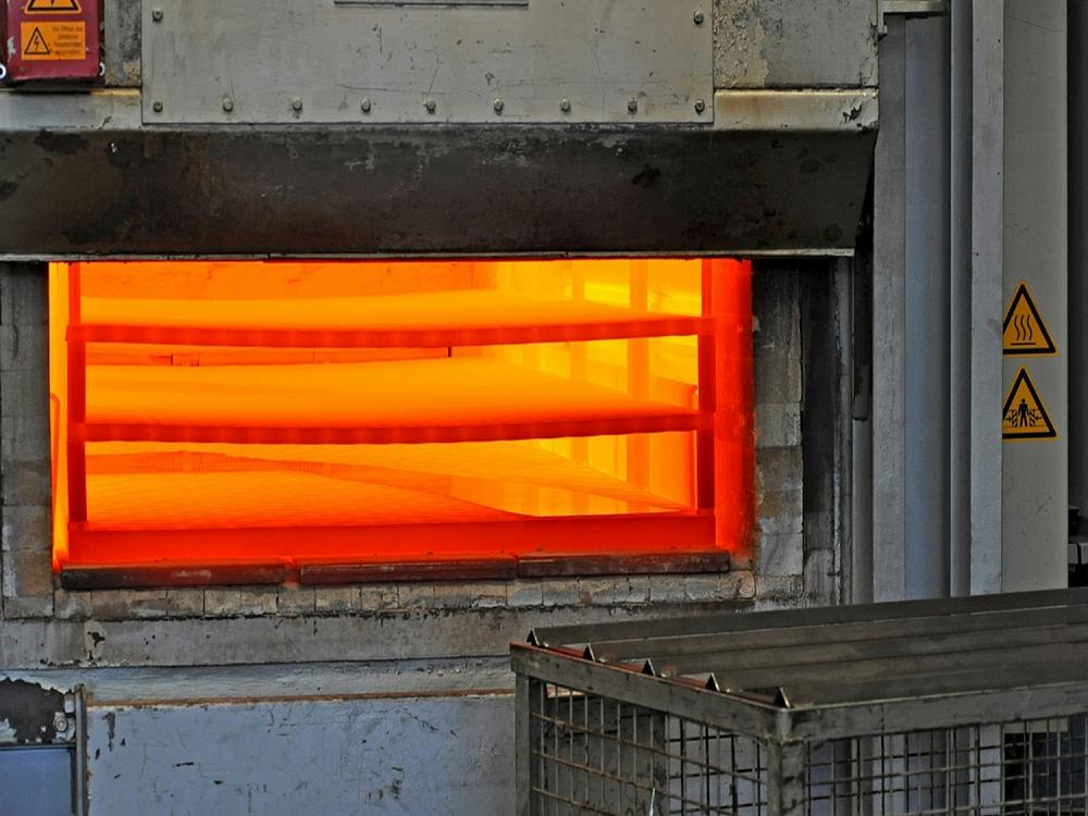 Industrial furnace for hot forming of prototype components – high-temperature process Open industrial furnace with glowing metal sheets during the hot forming process