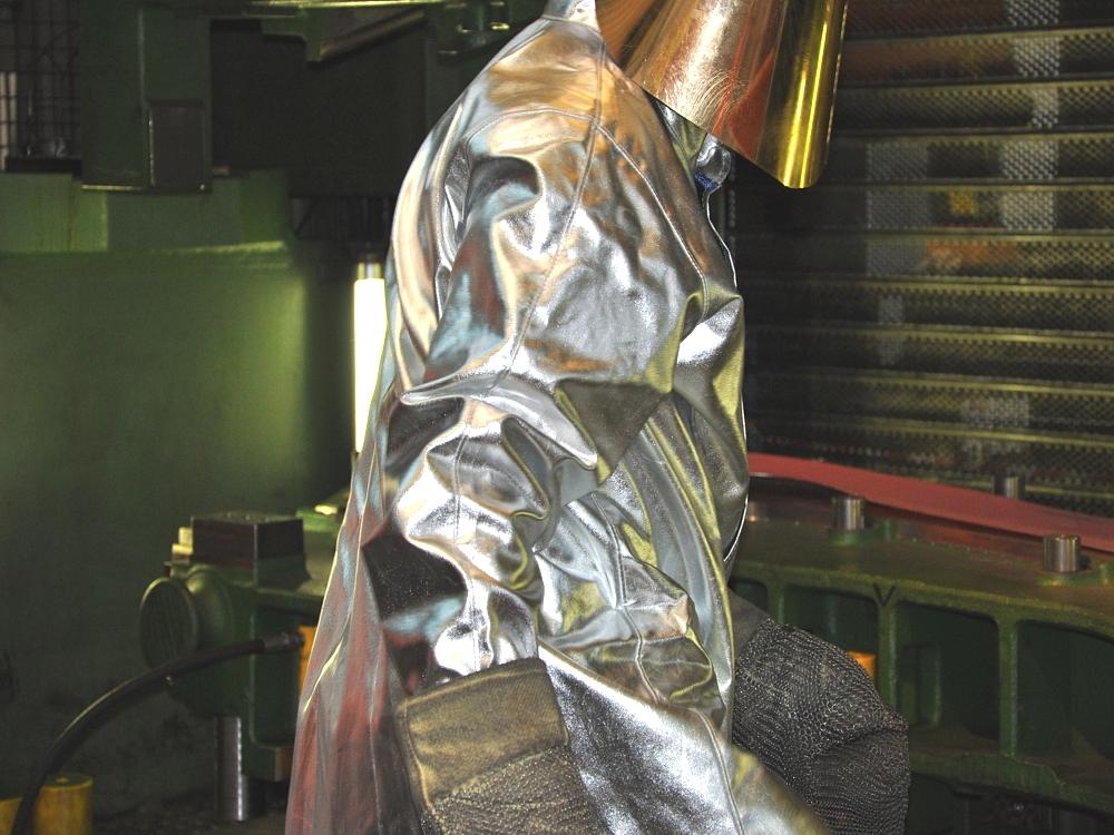 Hot forming of prototype components – protective equipment in high-temperature processes Worker wearing heat-protective clothing during the hot forming of a prototype component